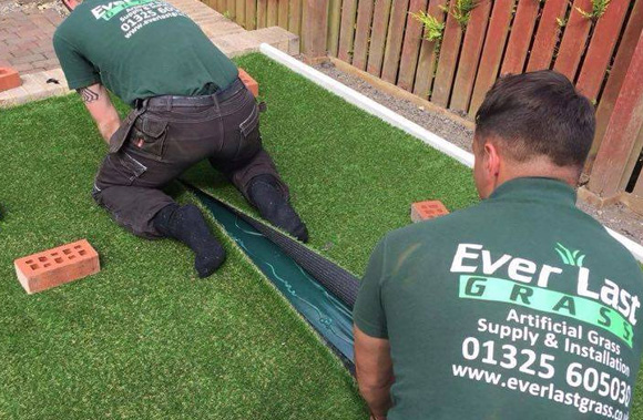 Everlast Artificial Grass installers in garden installing artificial grass